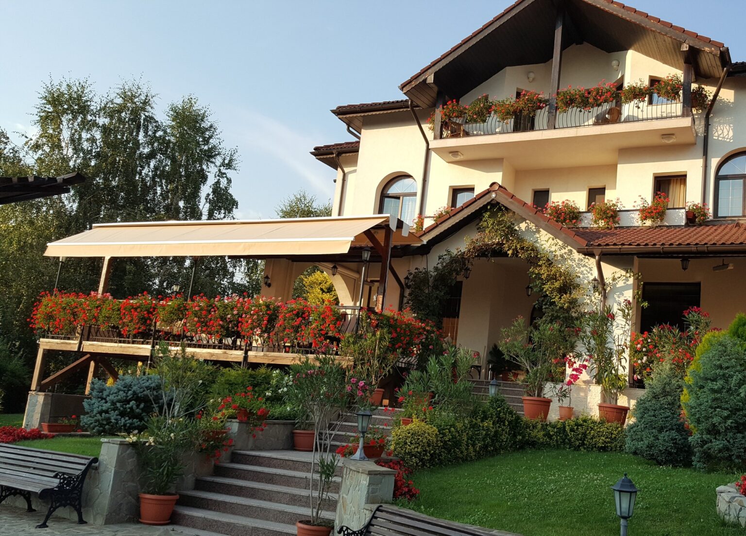 Pensiunea Casa Domnească – fațada și grădina cu flori